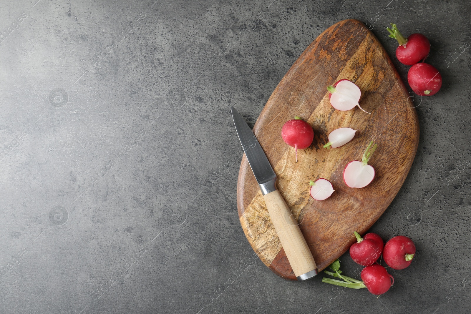 Cutting board with radishes and knife on grey table, flat lay. Space for text Photo of Cutting board with radishes and knife on grey table, flat lay. Space for text