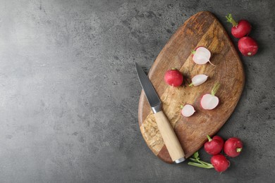 Photo of Cutting board with radishes and knife on grey table, flat lay. Space for text