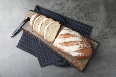 Photo of Cutting board with fresh bread on grey table, top view