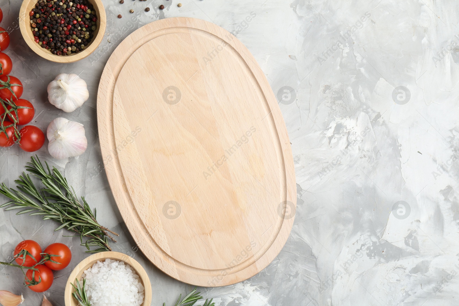 Photo of Cutting board with tomatoes and spices on grey textured table, flat lay. Space for text