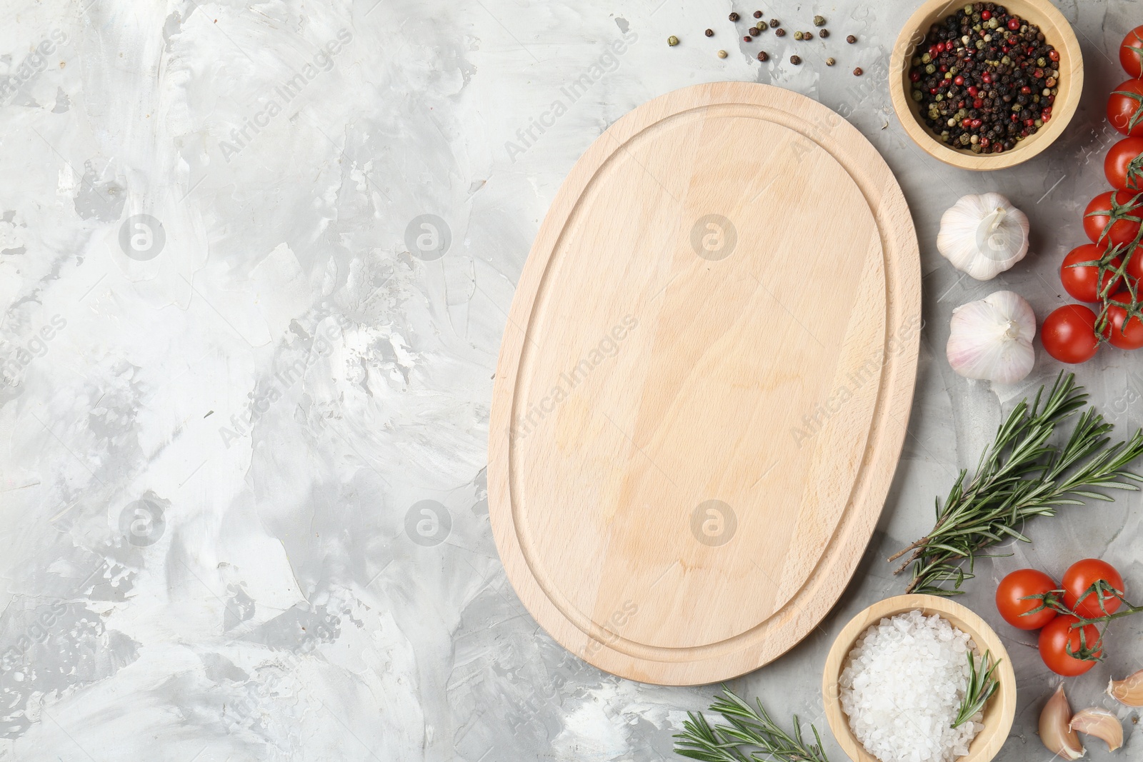 Photo of Cutting board with tomatoes and spices on grey textured table, flat lay. Space for text