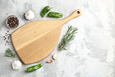 Photo of Cutting board with spices on grey textured table, flat lay. Space for text