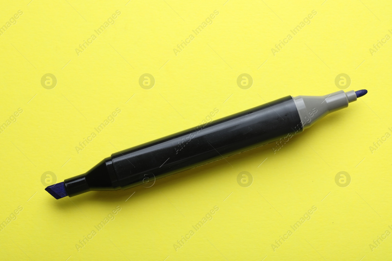 Photo of One double sided marker on yellow background, top view