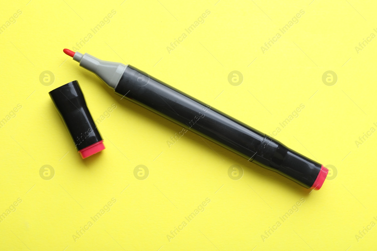 Photo of One double sided marker on yellow background, top view