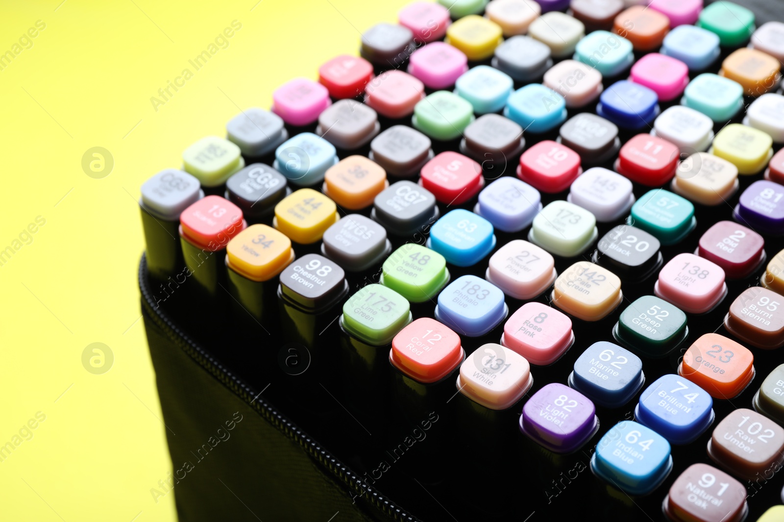 Photo of Different double sided markers on yellow background, closeup