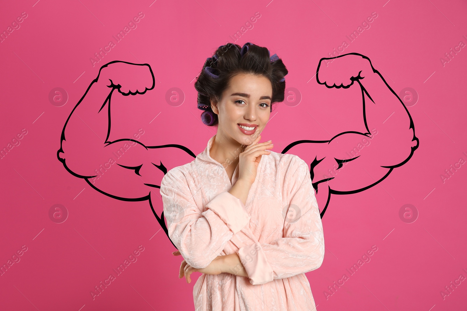 Image of Beautiful young woman with drawing of strong arms behind her on pink background