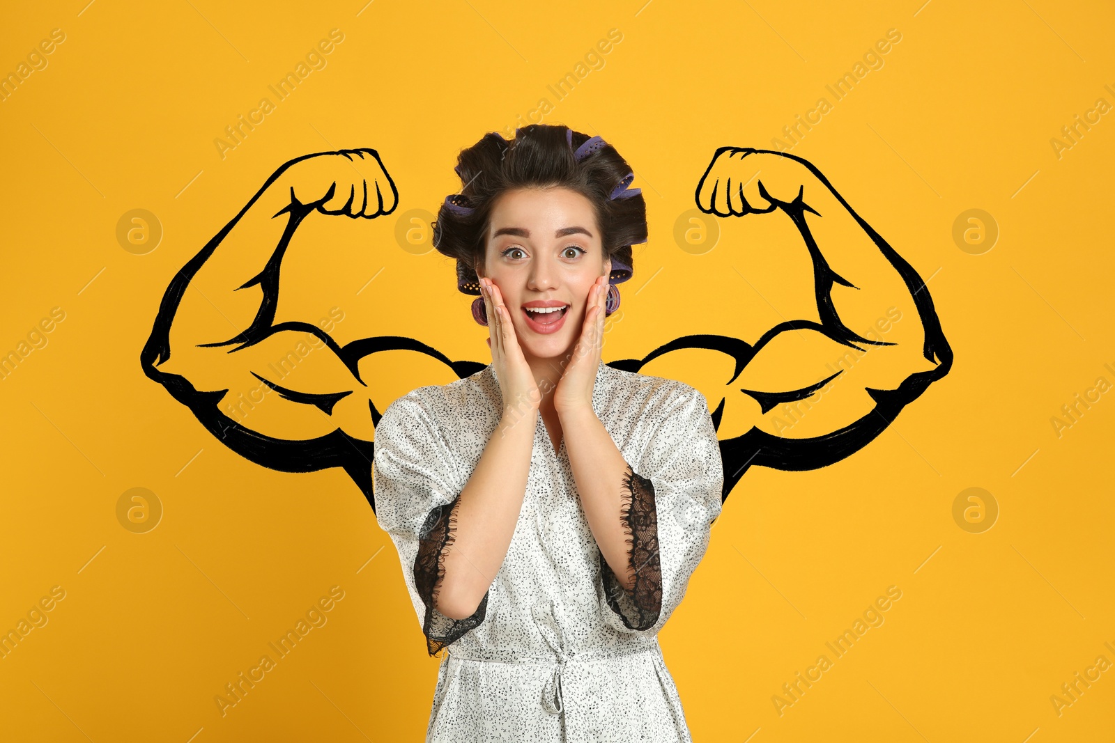 Image of Surprised young woman with drawing of strong arms behind her on orange background