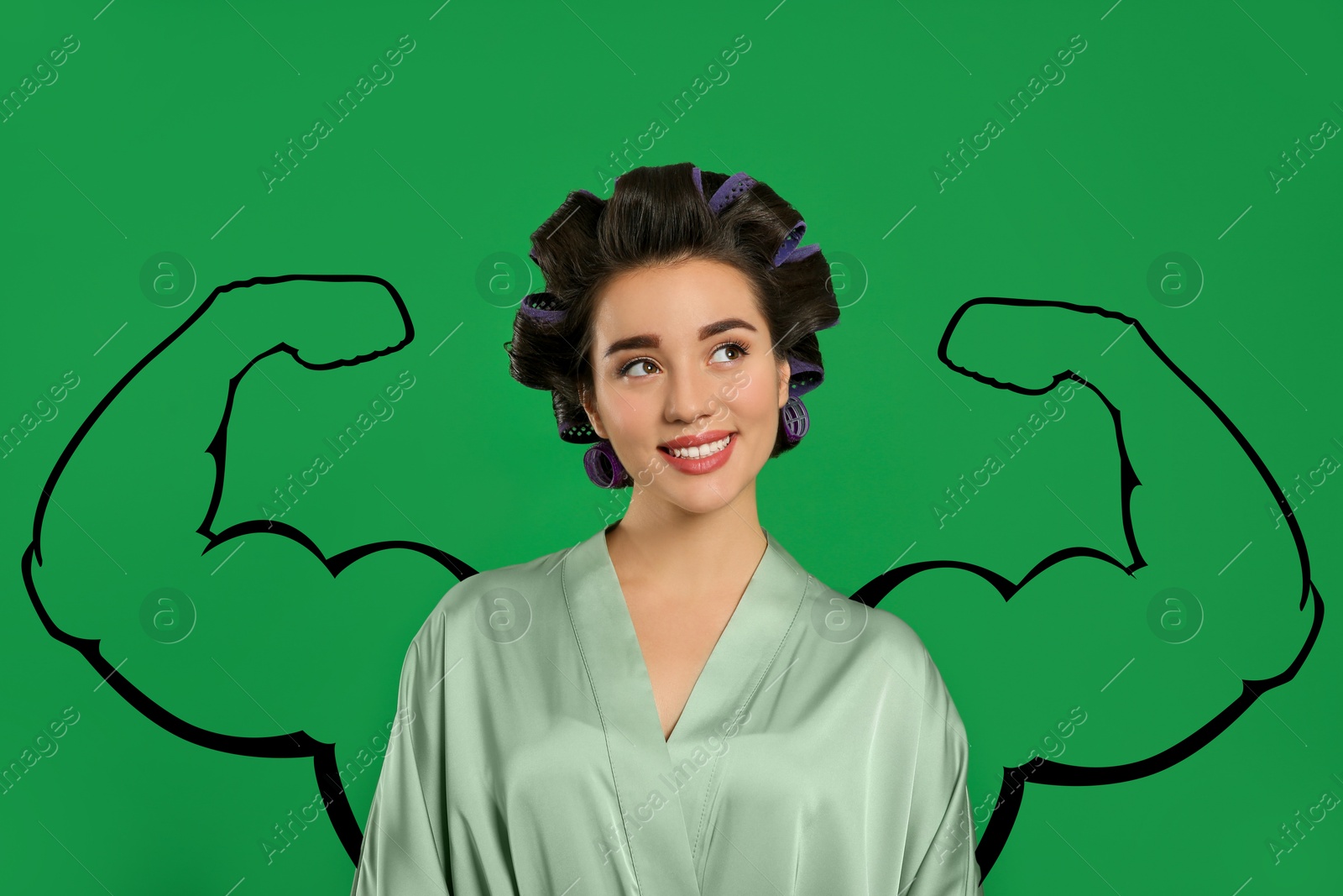 Image of Beautiful young woman with drawing of strong arms behind her on green background