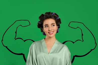 Image of Beautiful young woman with drawing of strong arms behind her on green background