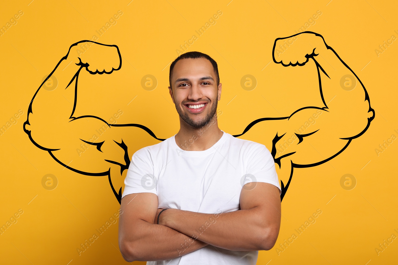 Image of Handsome young man with drawing of strong arms behind him on golden background