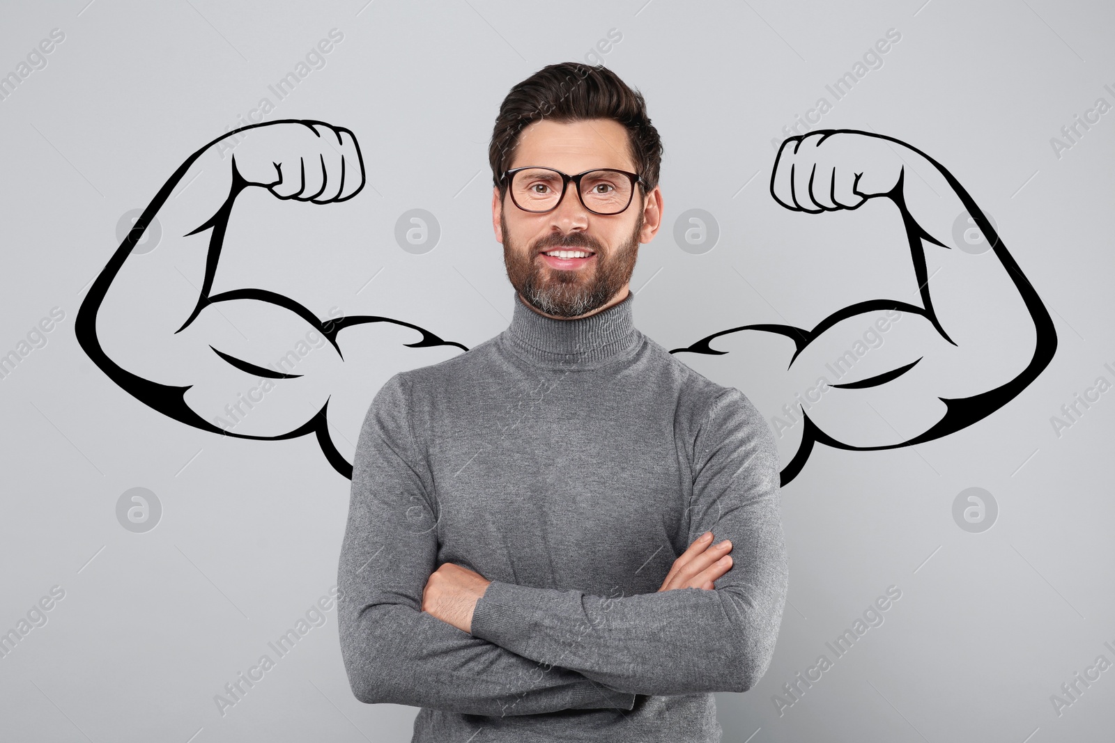 Image of Handsome man with drawing of strong arms behind him on grey background