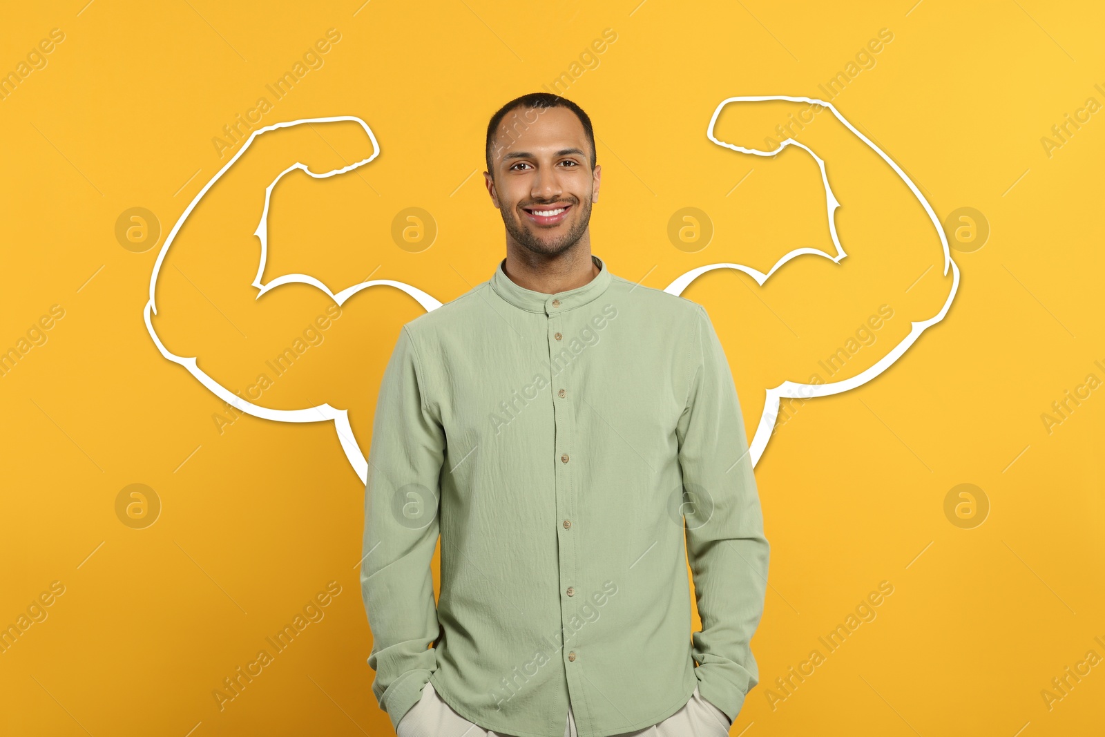 Image of Handsome young man with drawing of strong arms behind him on orange background