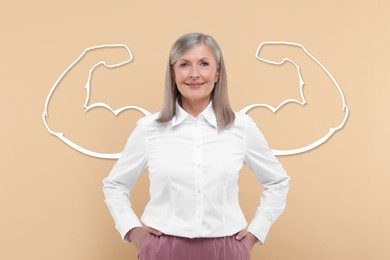 Image of Beautiful mature woman with drawing of strong arms behind her on beige background