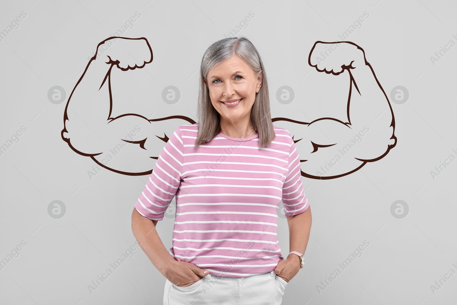 Image of Beautiful mature woman with drawing of strong arms behind her on grey background