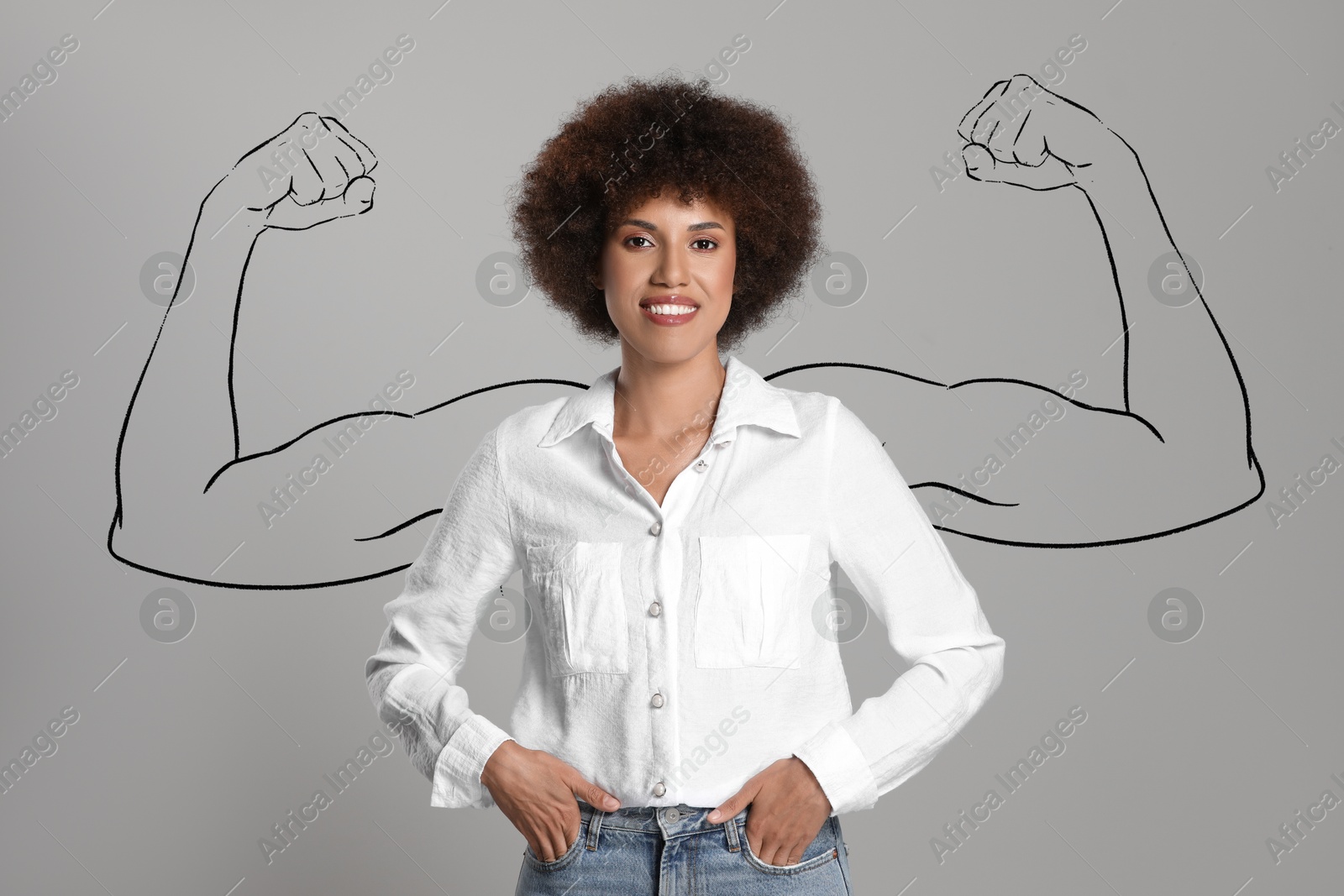 Image of Confident beautiful woman with drawing of strong arms behind her on grey background