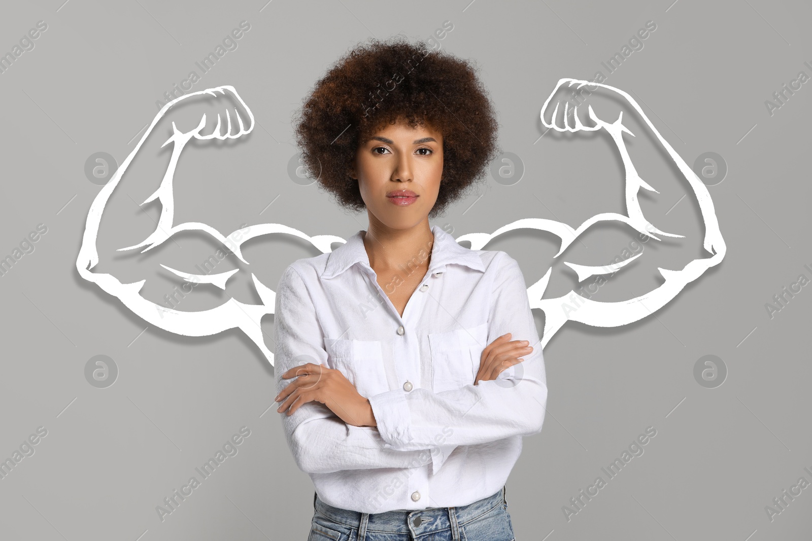 Image of Confident beautiful woman with drawing of strong arms behind her on grey background