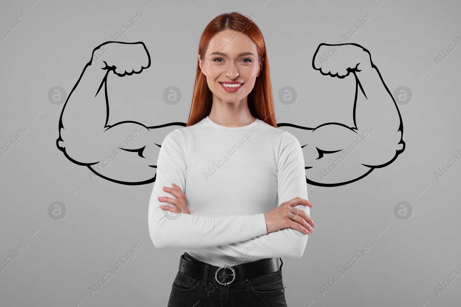 Image of Confident beautiful woman with drawing of strong arms behind her on grey background