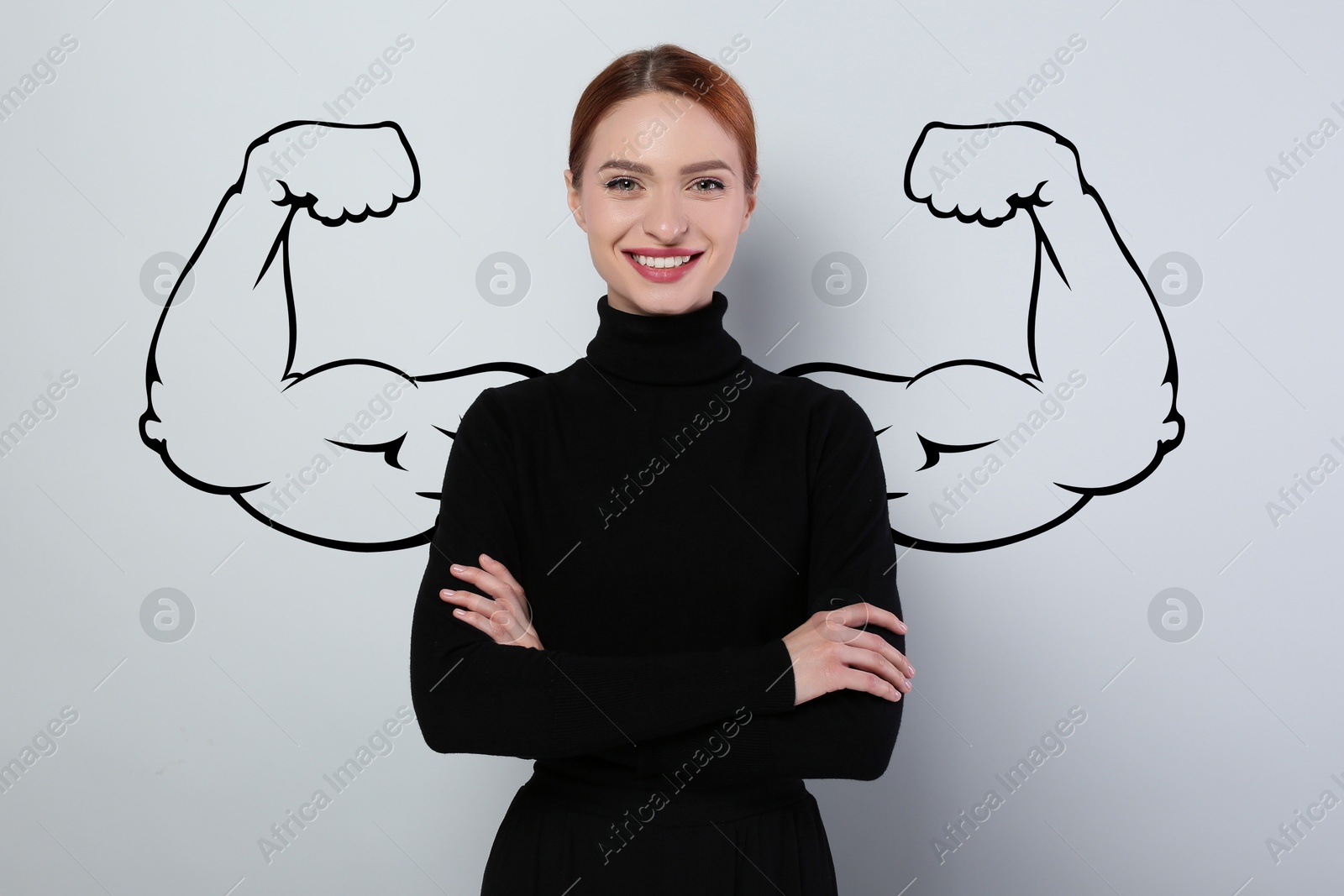 Image of Confident beautiful woman with drawing of strong arms behind her on grey background