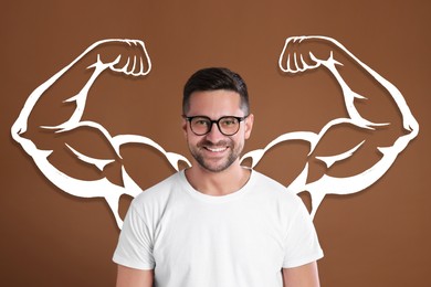 Image of Happy man with drawing of strong arms behind him on brown background