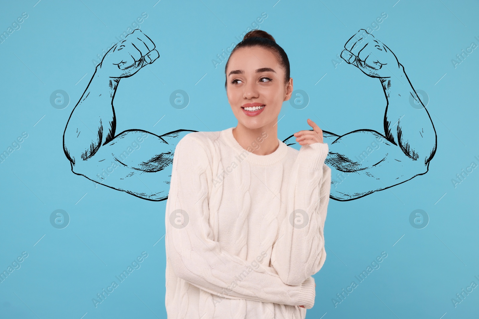 Image of Beautiful young woman with drawing of strong arms behind her on light blue background