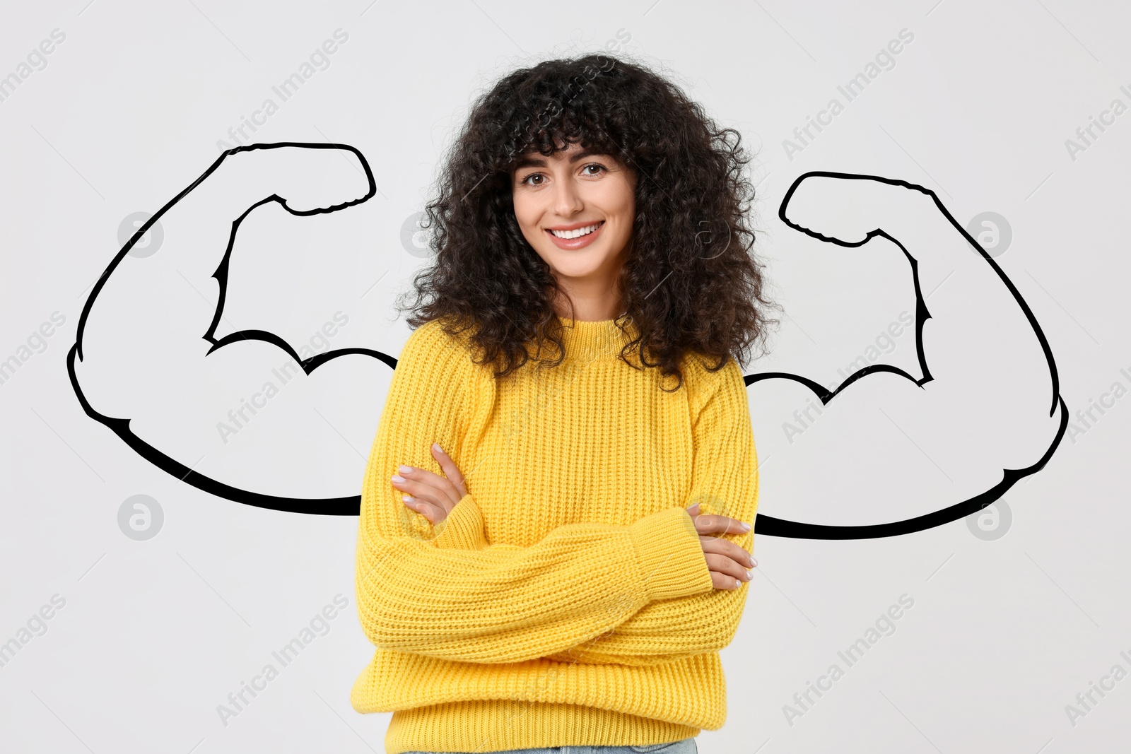 Image of Confident beautiful woman with drawing of strong arms behind her on light grey background