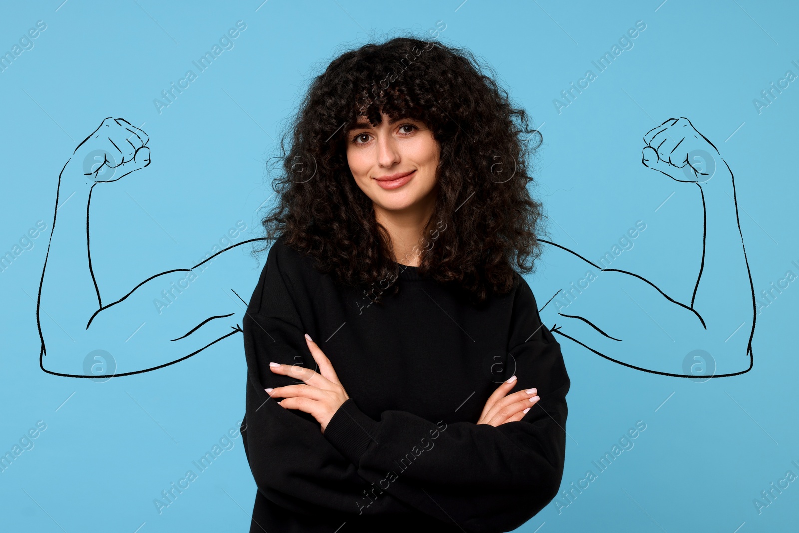 Image of Confident beautiful woman with drawing of strong arms behind her on light blue background