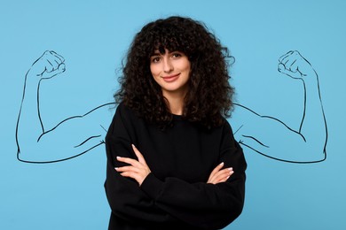 Image of Confident beautiful woman with drawing of strong arms behind her on light blue background