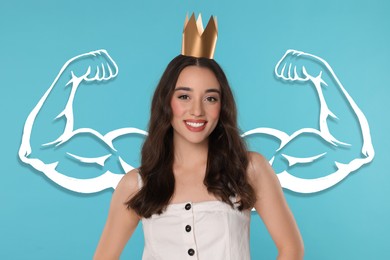 Image of Confident beautiful woman wearing golden crown on light blue background with drawing of strong arms behind her