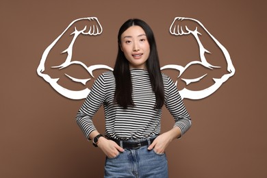 Image of Beautiful woman with drawing of strong arms behind her on brown background