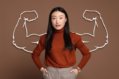 Image of Confident beautiful woman with drawing of strong arms behind her on brown background