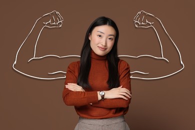 Confident beautiful woman with drawing of strong arms behind her on brown background