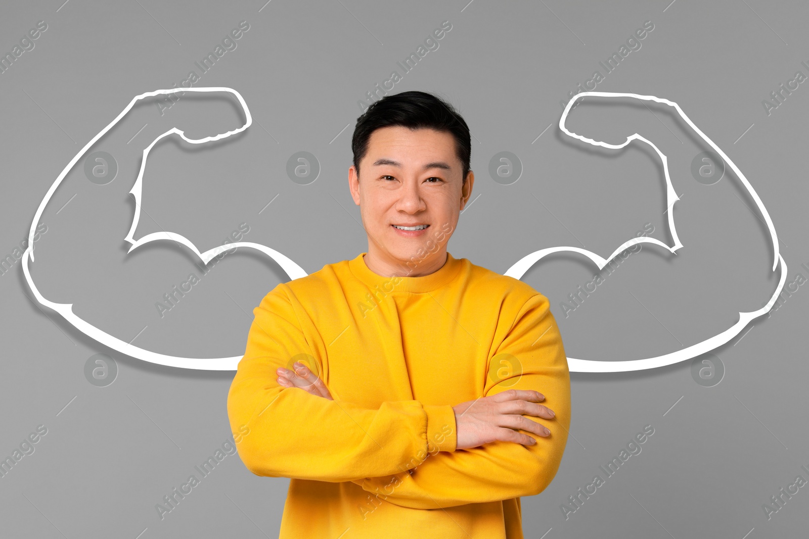 Image of Confident man with drawing of strong arms behind him on grey background