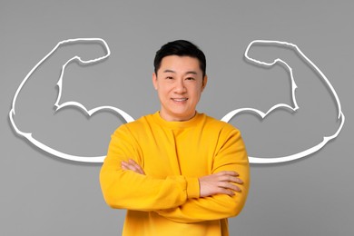 Image of Confident man with drawing of strong arms behind him on grey background