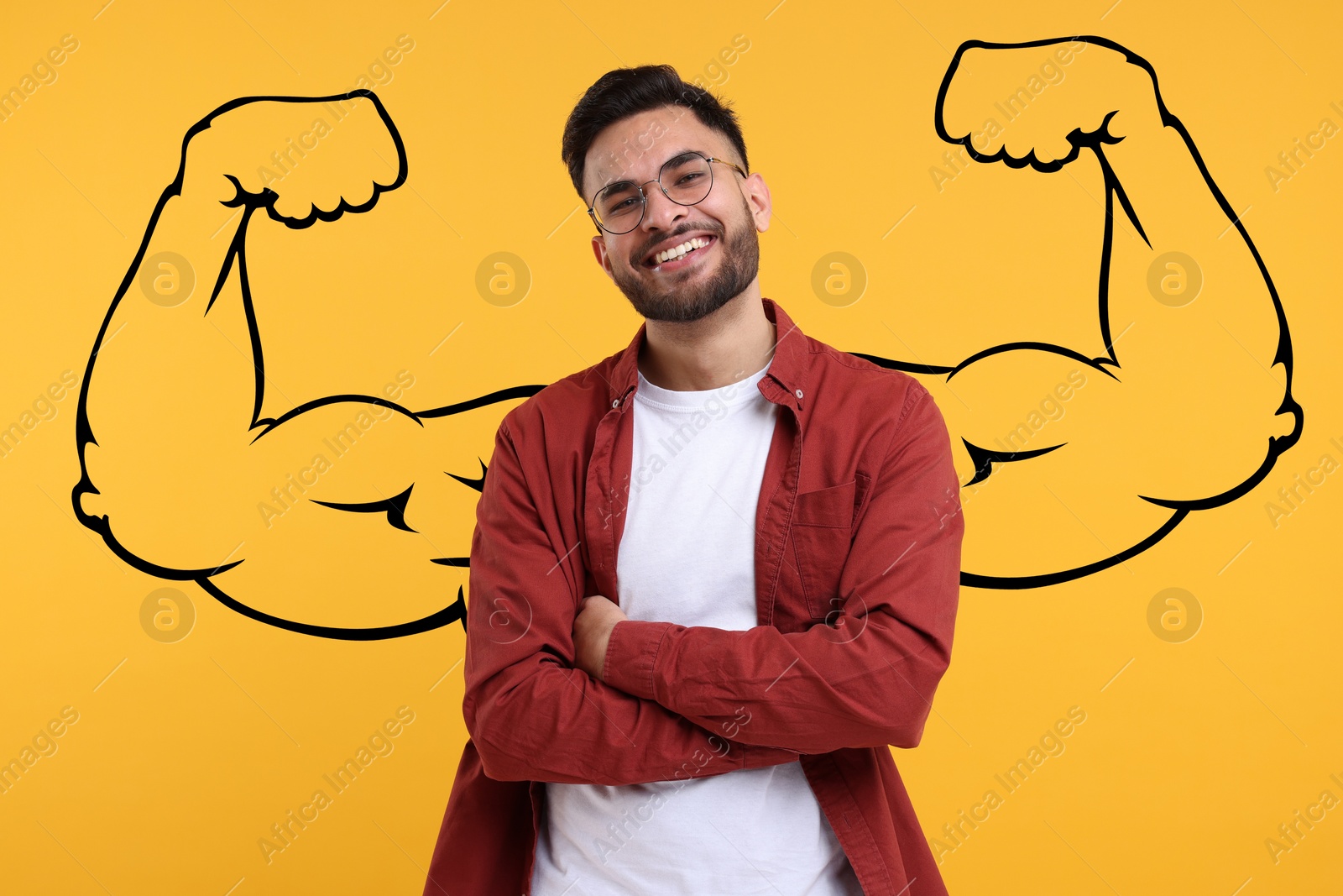 Image of Handsome young man with drawing of strong arms behind him on orange background