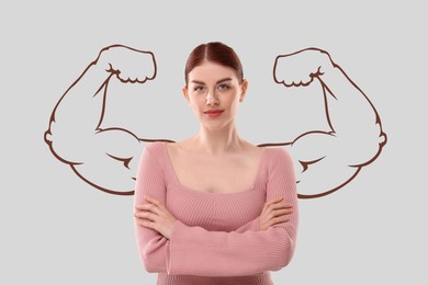 Image of Confident beautiful woman with drawing of strong arms behind her on light grey background