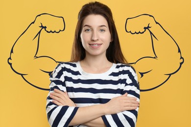 Image of Confident beautiful woman with drawing of strong arms behind her on orange background