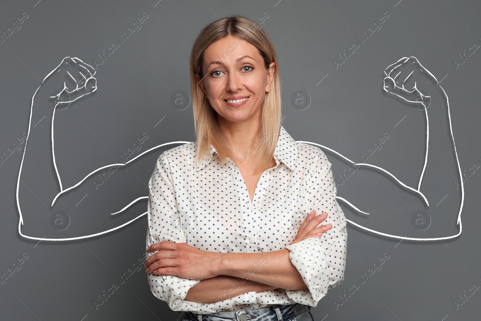 Image of Confident beautiful woman with drawing of strong arms behind her on grey background