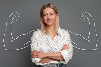 Image of Confident beautiful woman with drawing of strong arms behind her on grey background