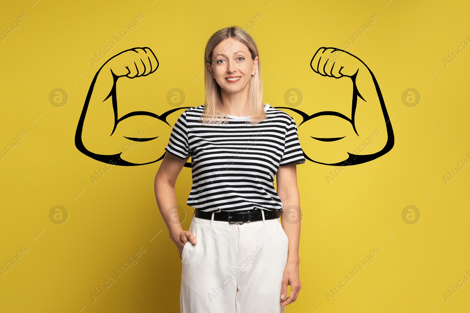 Image of Confident beautiful woman with drawing of strong arms behind her on golden background