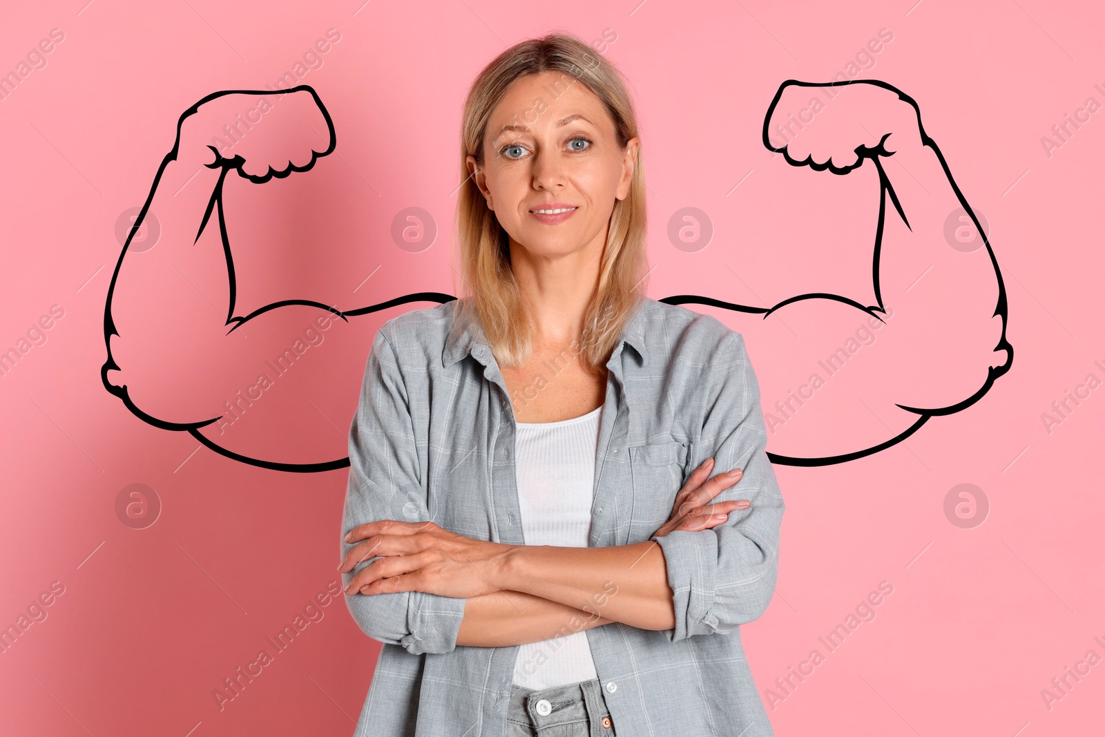 Image of Confident beautiful woman with drawing of strong arms behind her on pink background