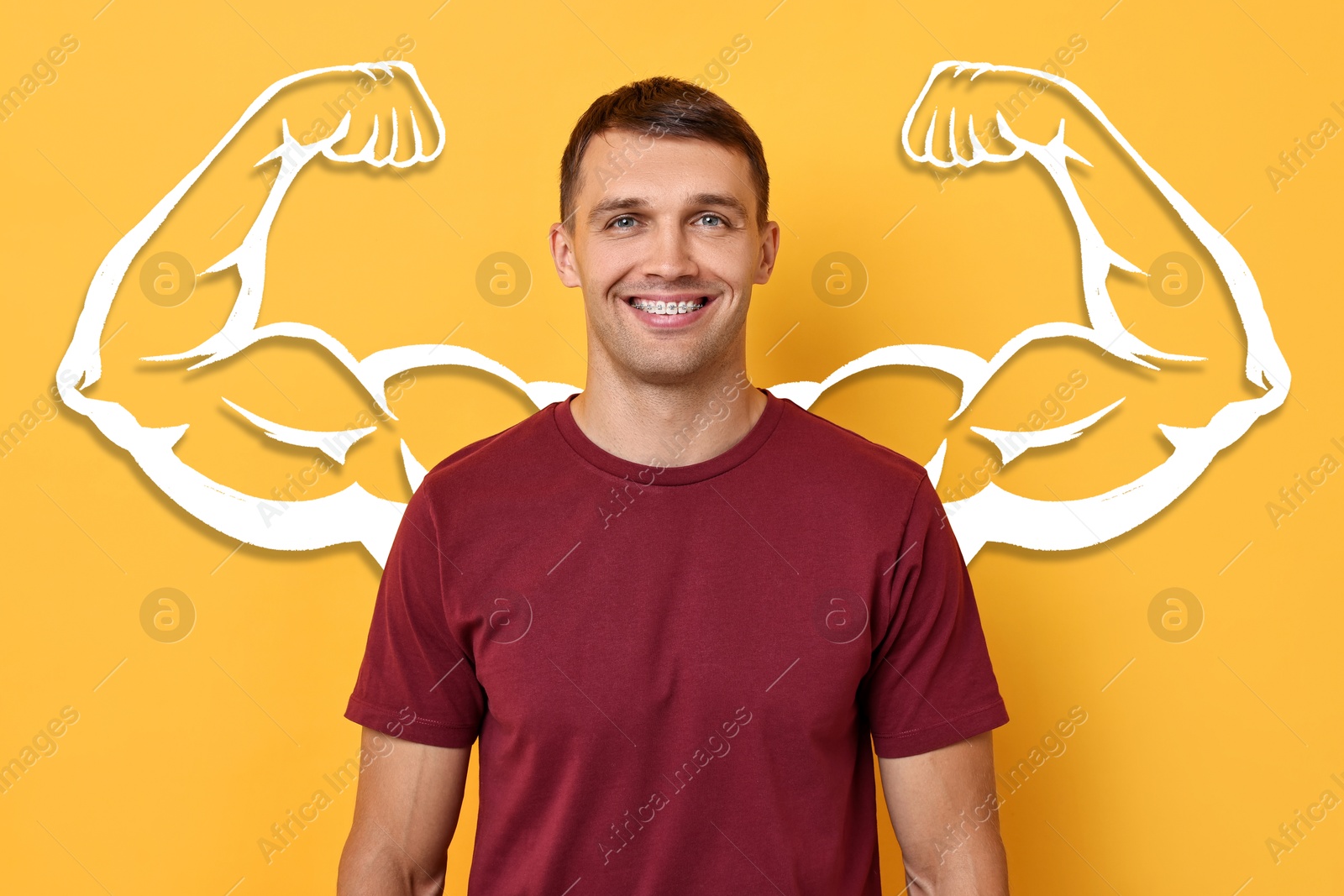 Image of Handsome man with drawing of strong arms behind him on orange background