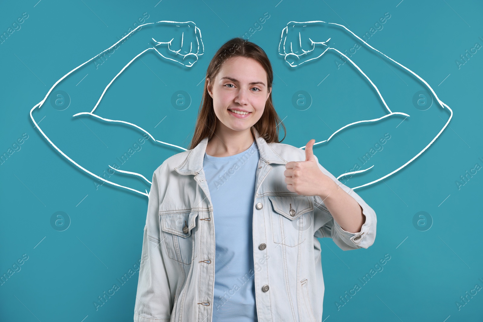 Image of Beautiful young woman with drawing of strong arms behind her on pastel blue background