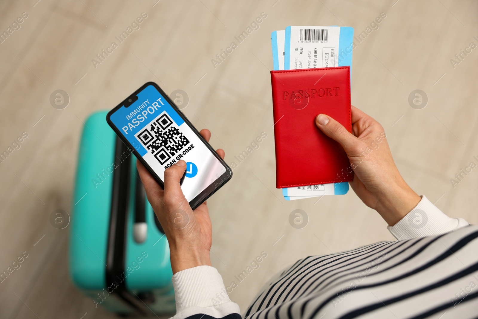 Image of Tourist with passport, flight tickets and mobile phone indoors, above view. Immunity passport app with QR code on device screen