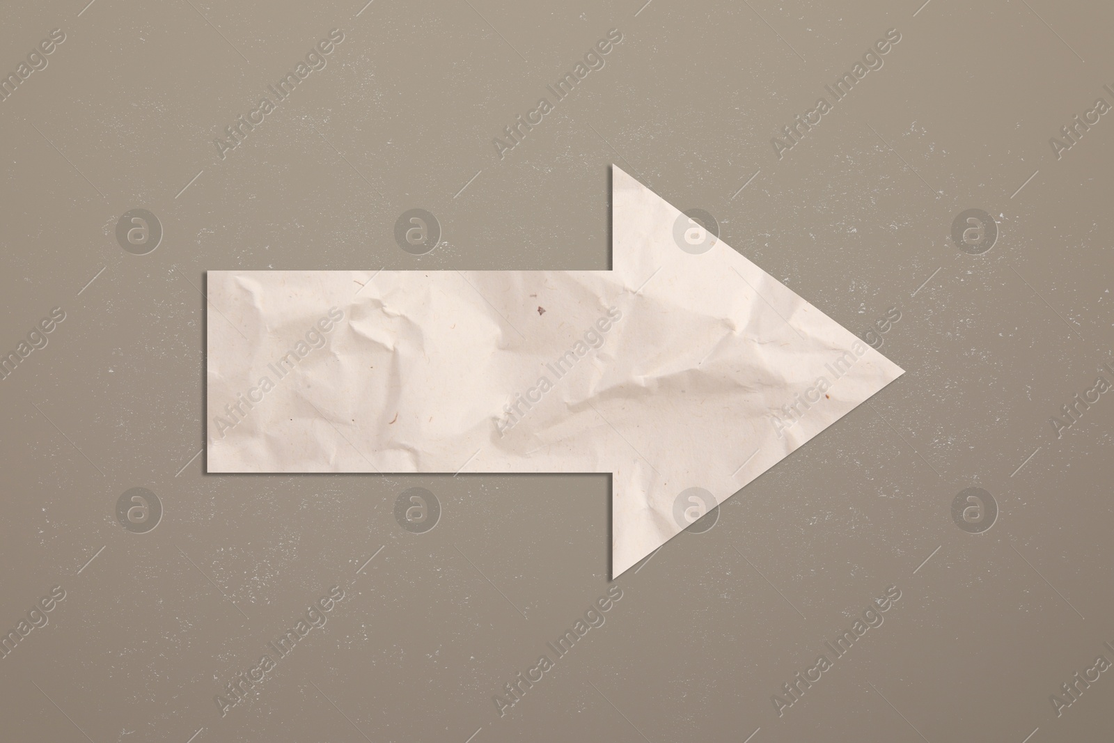 Image of One paper arrow on dark beige background