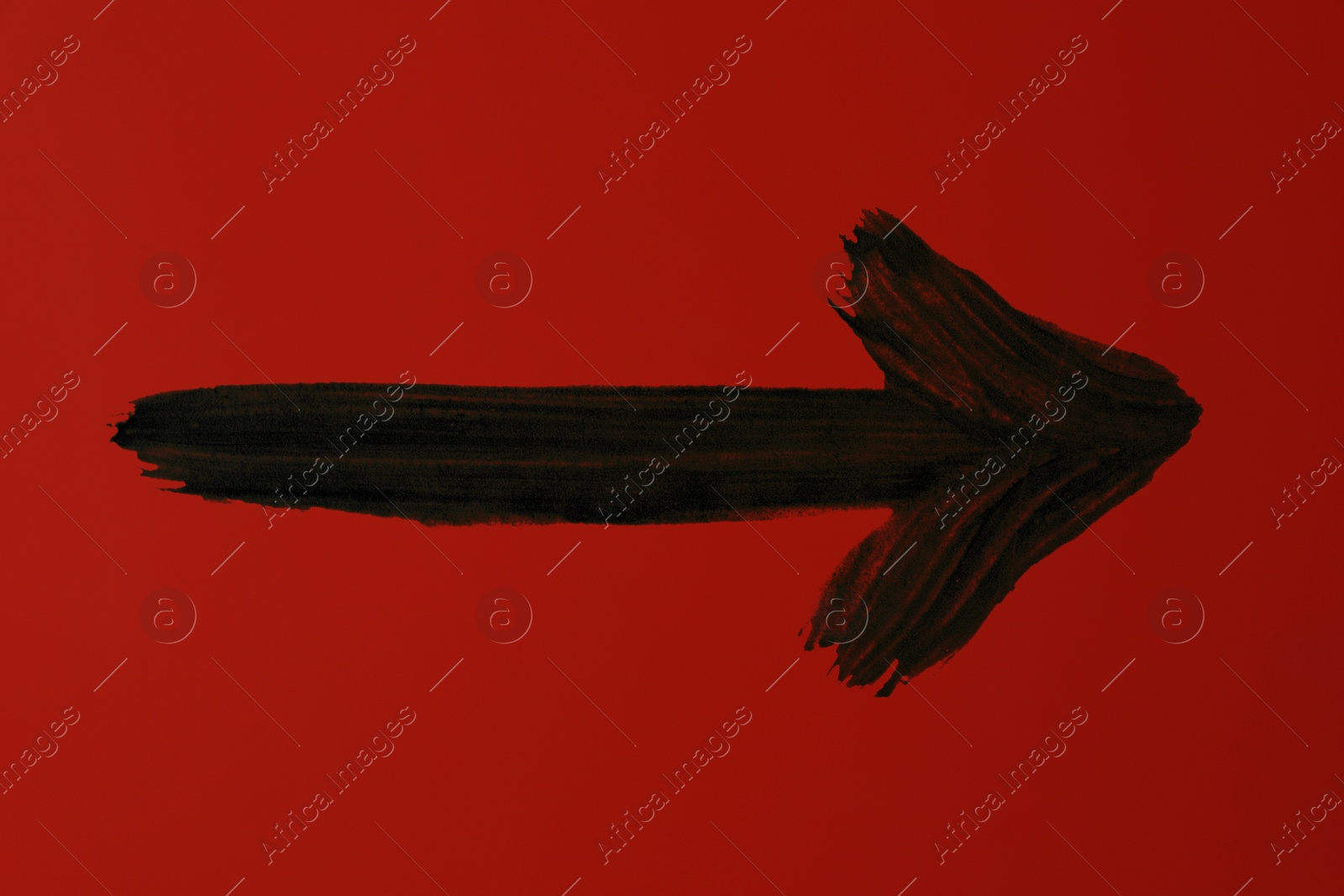 Image of One black painted arrow on red background