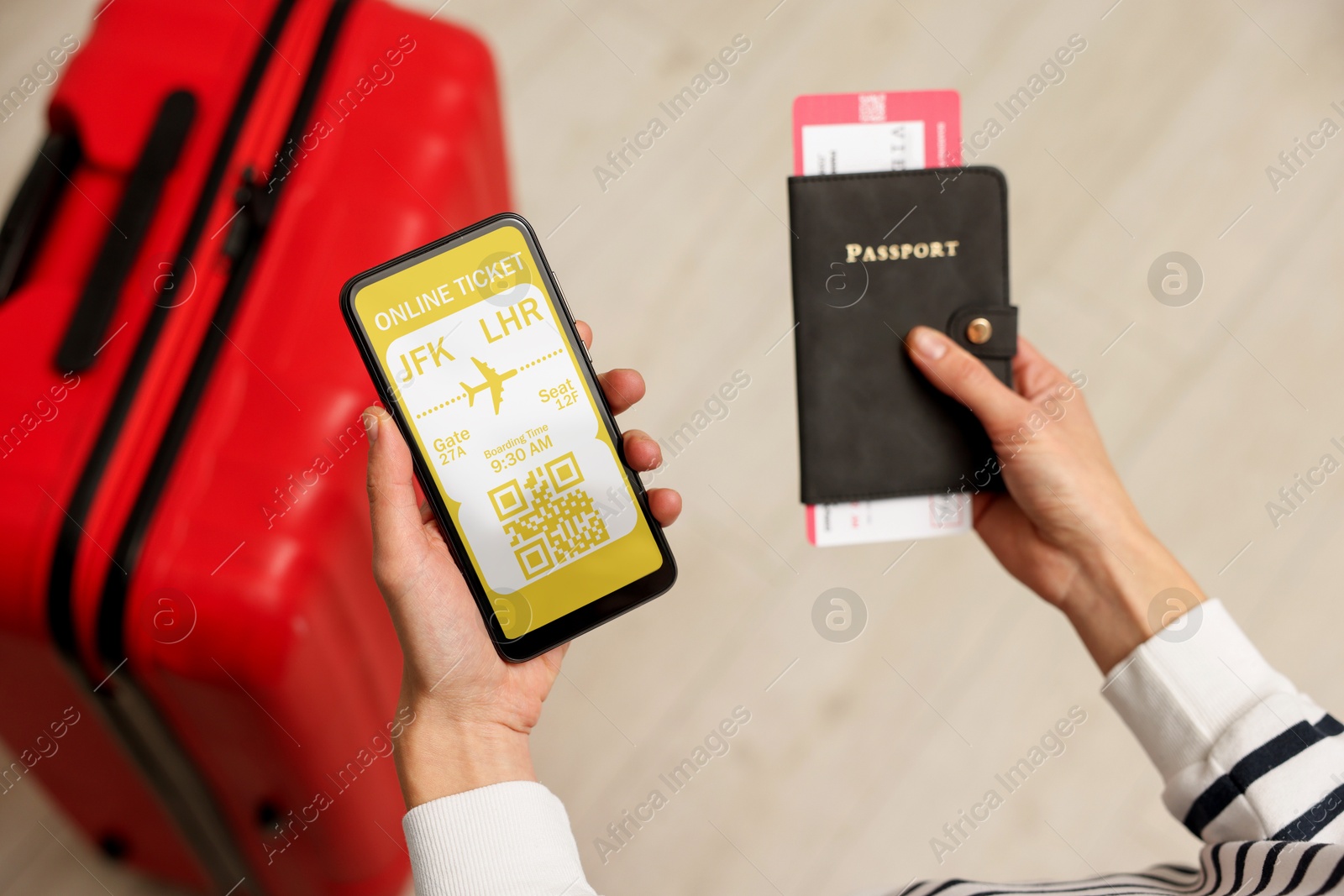 Image of Tourist with passport, flight ticket and mobile phone indoors, above view. Online ticket with QR code on device screen