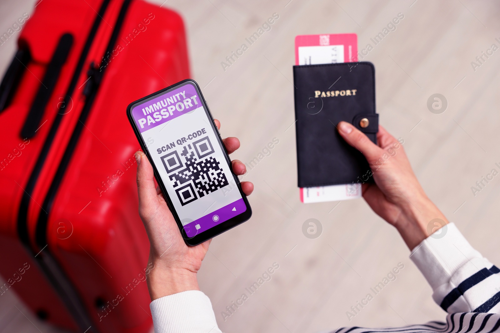 Image of Tourist with passport, flight ticket and mobile phone indoors, above view. Immunity passport app with QR code on device screen