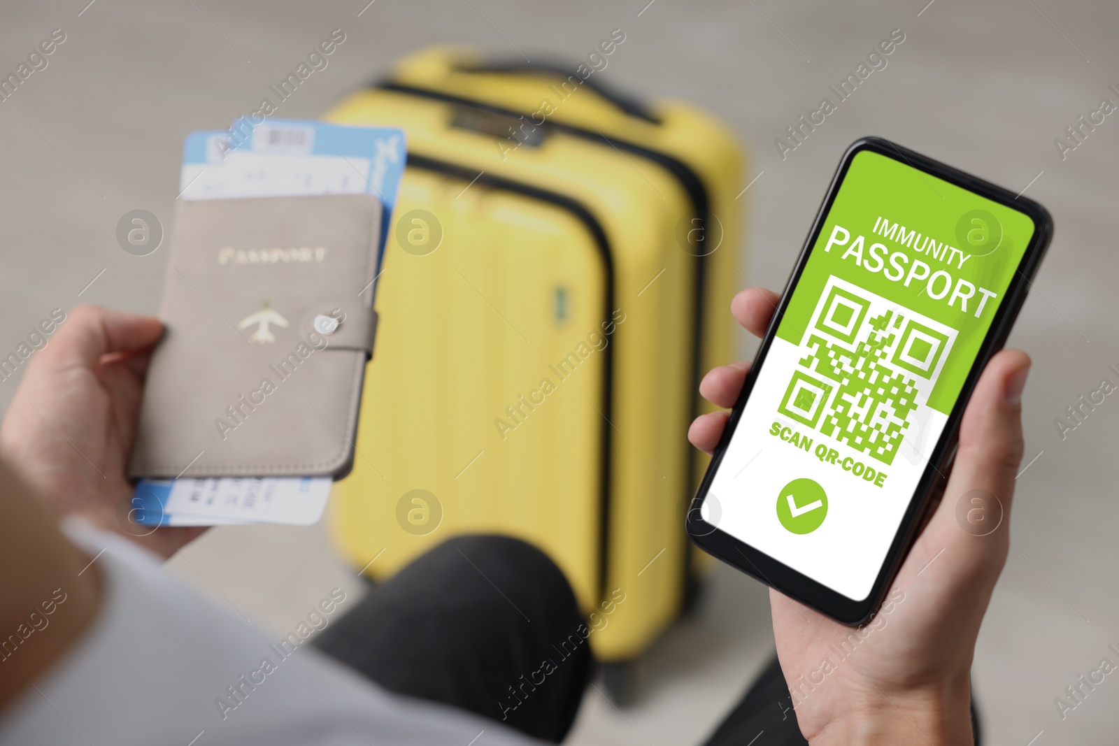 Image of Tourist with passport, flight tickets and mobile phone indoors, above view. Immunity passport app with QR code on device screen