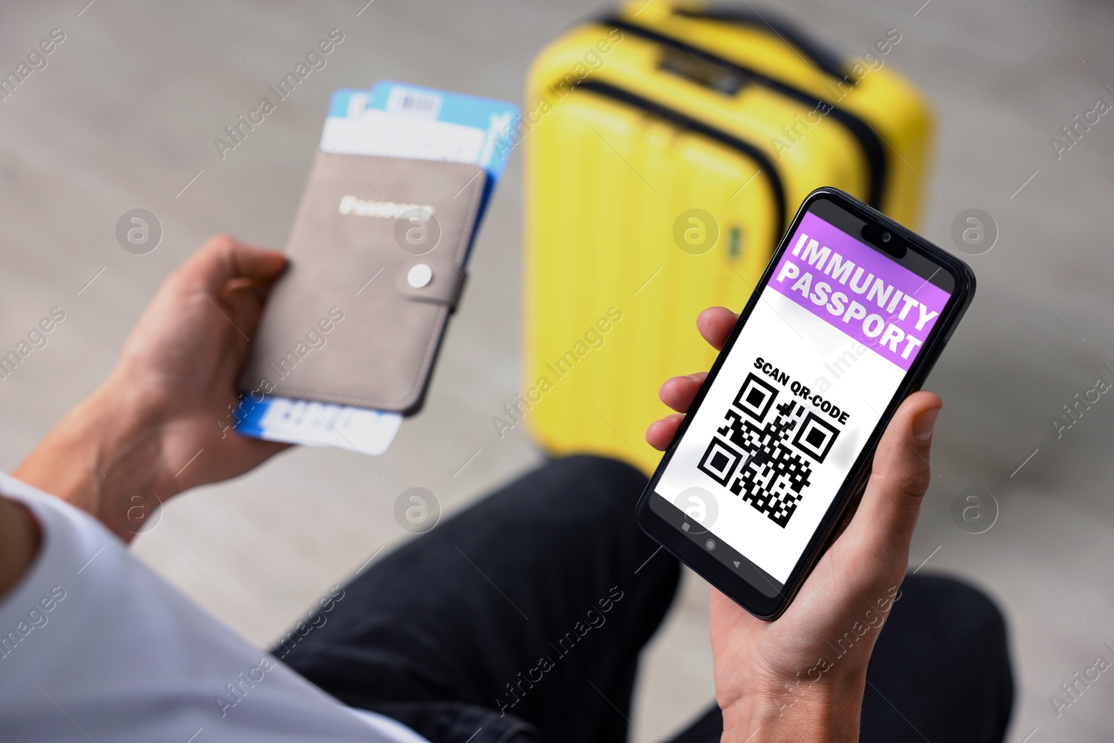 Image of Tourist with passport, flight tickets and mobile phone indoors, above view. Immunity passport app with QR code on device screen