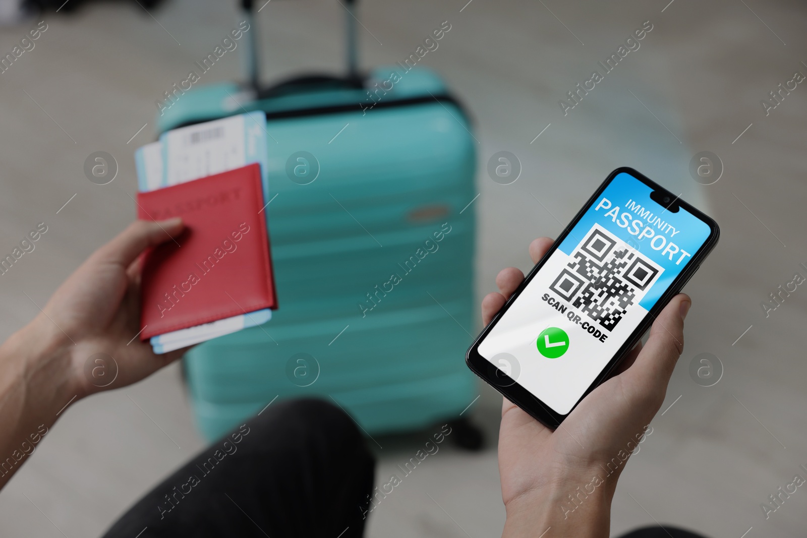 Image of Tourist with passport, flight tickets and mobile phone indoors, above view. Immunity passport app with QR code on device screen